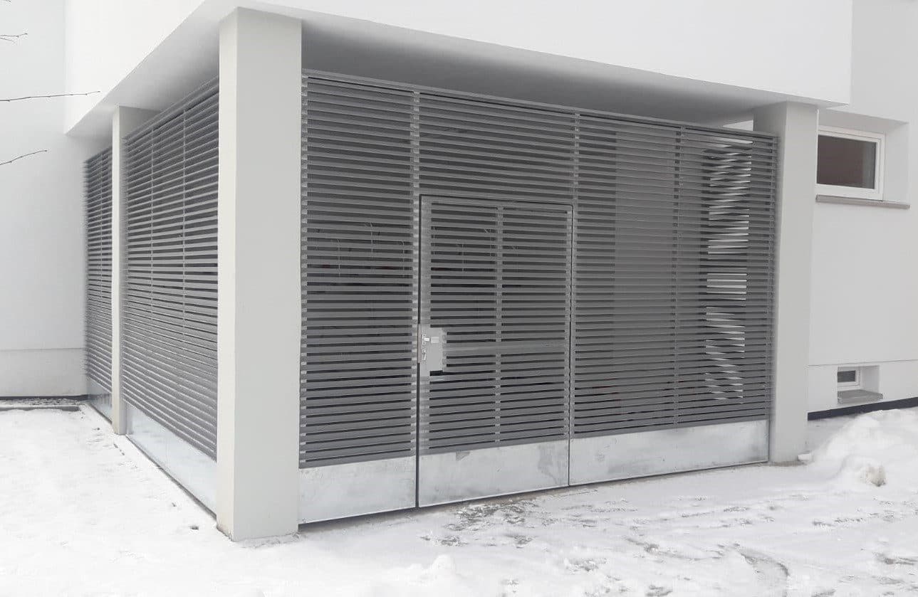 Geschlossene Lamelleneinhausung aus Metall an einem Gebäude