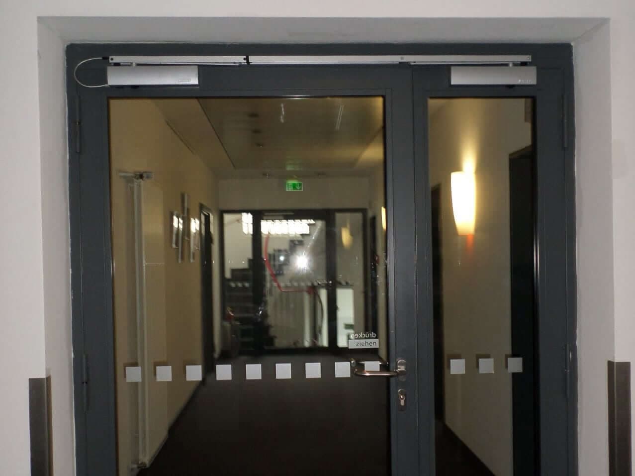 Zweiflügelige Metalltür mit Glaseinsatz und Türschließer