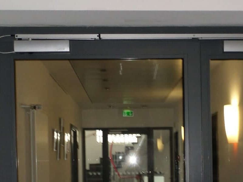 Türschließer oberhalb einer zweiflügeligen Metalltür