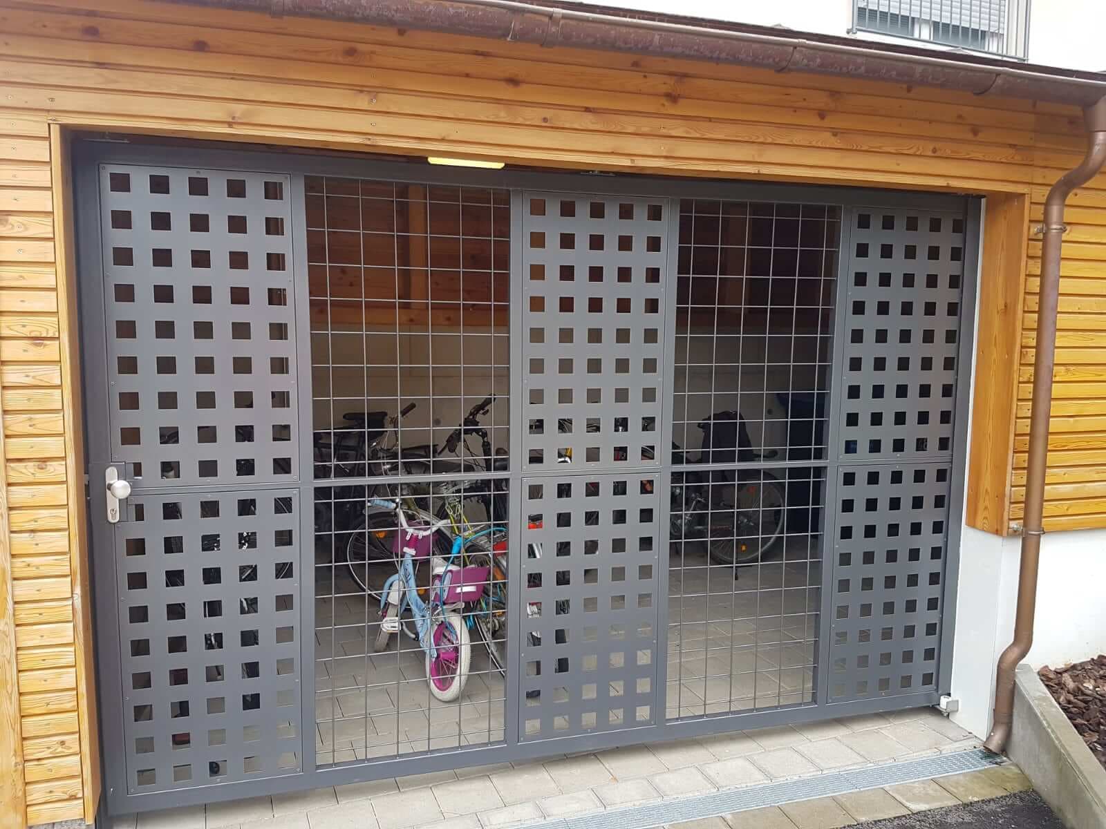 Metalltor mit Lochblech- und Gitterfüllung vor einem Fahrradabstellplatz