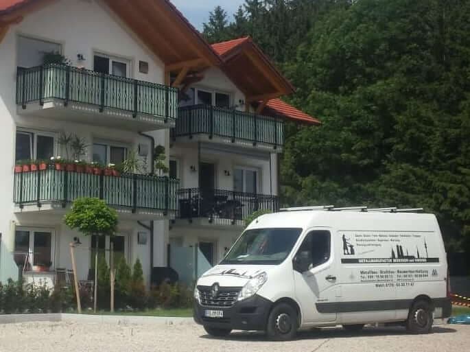 Wohnhaus mit schwarzen Balkongeländern und Zierelementen