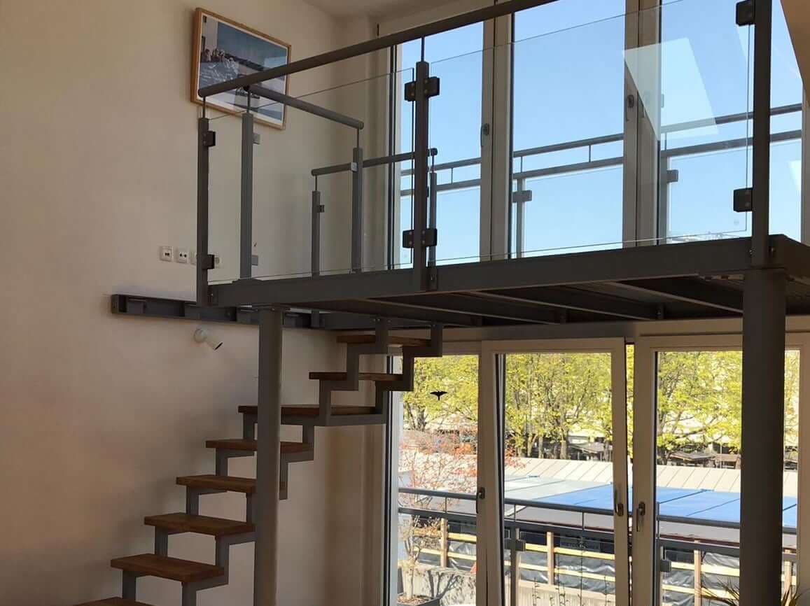Offene Holz-Metall-Treppe mit Galeriegeländer und Glasfüllung