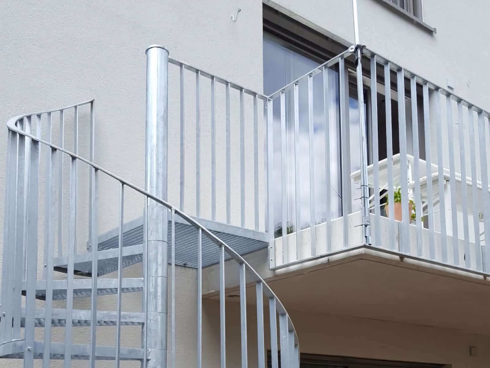 Außenspindeltreppe aus Metall mit Stabgeländer an einem Balkon